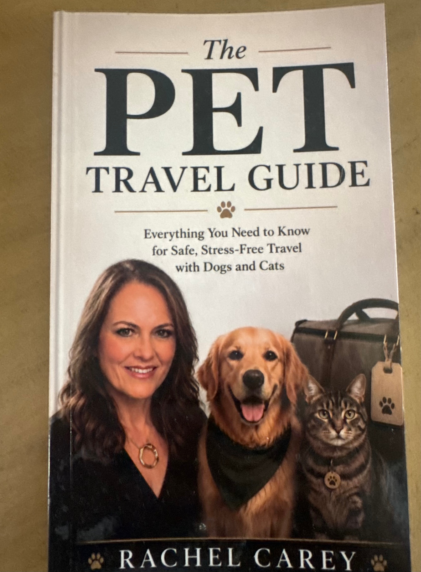Front cover of The Pet Travel Guide by Rachel Carey, showing Rachel with a golden retriever and a tabby cat.