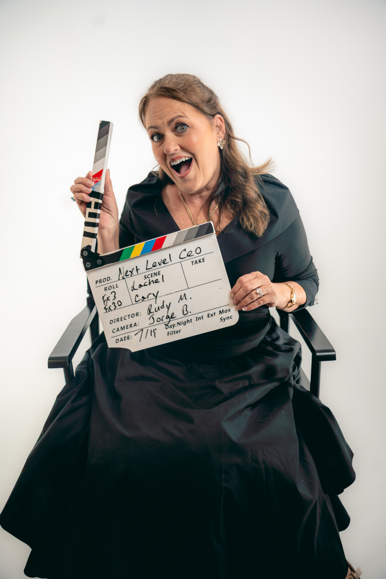 Rachel Carey holding a Next Level CEO TV clapperboard